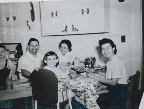 An old family photograph of a family round a kitchen table, attached to a question
